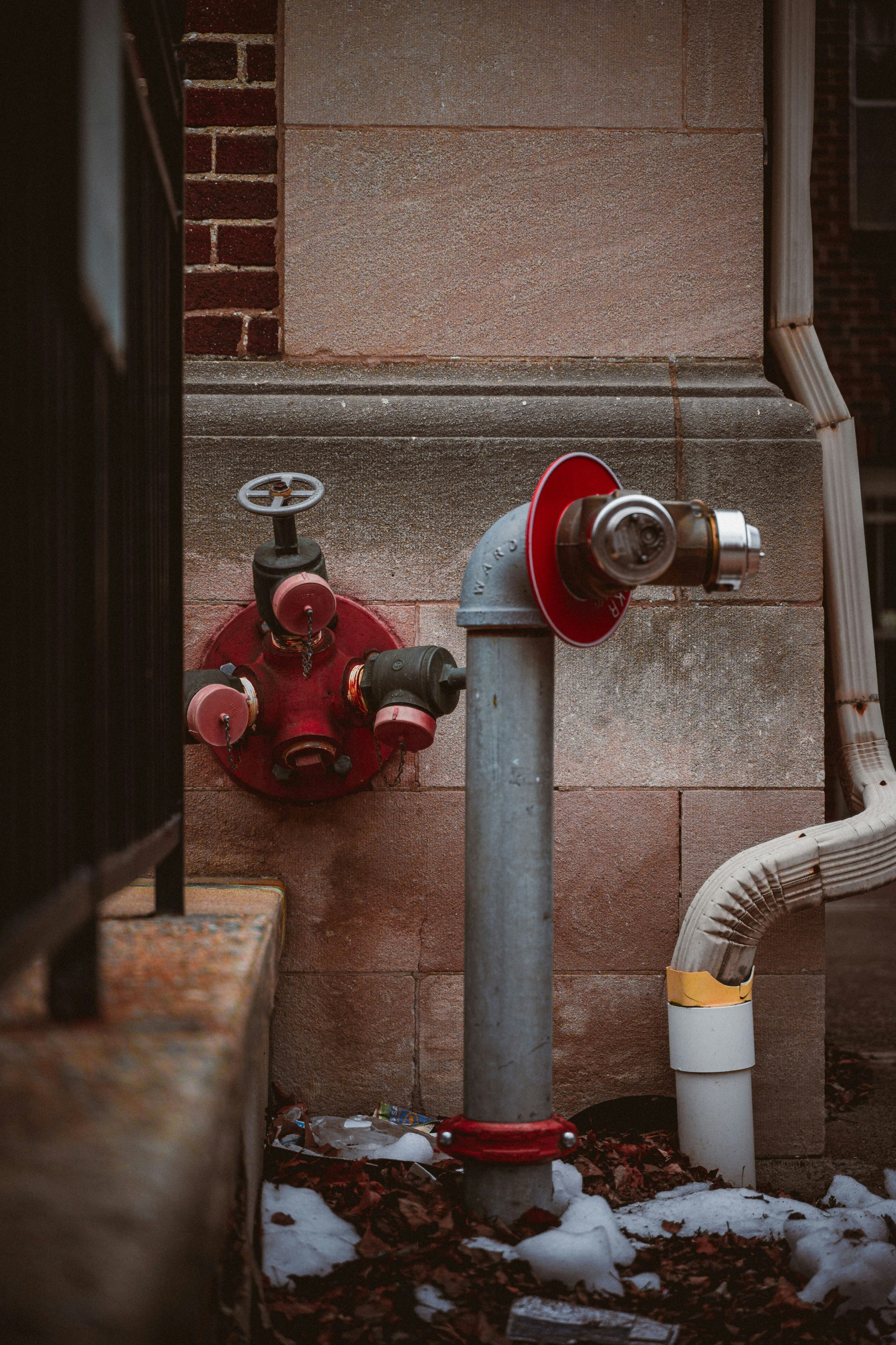 A red fire hydrant sitting next to a building